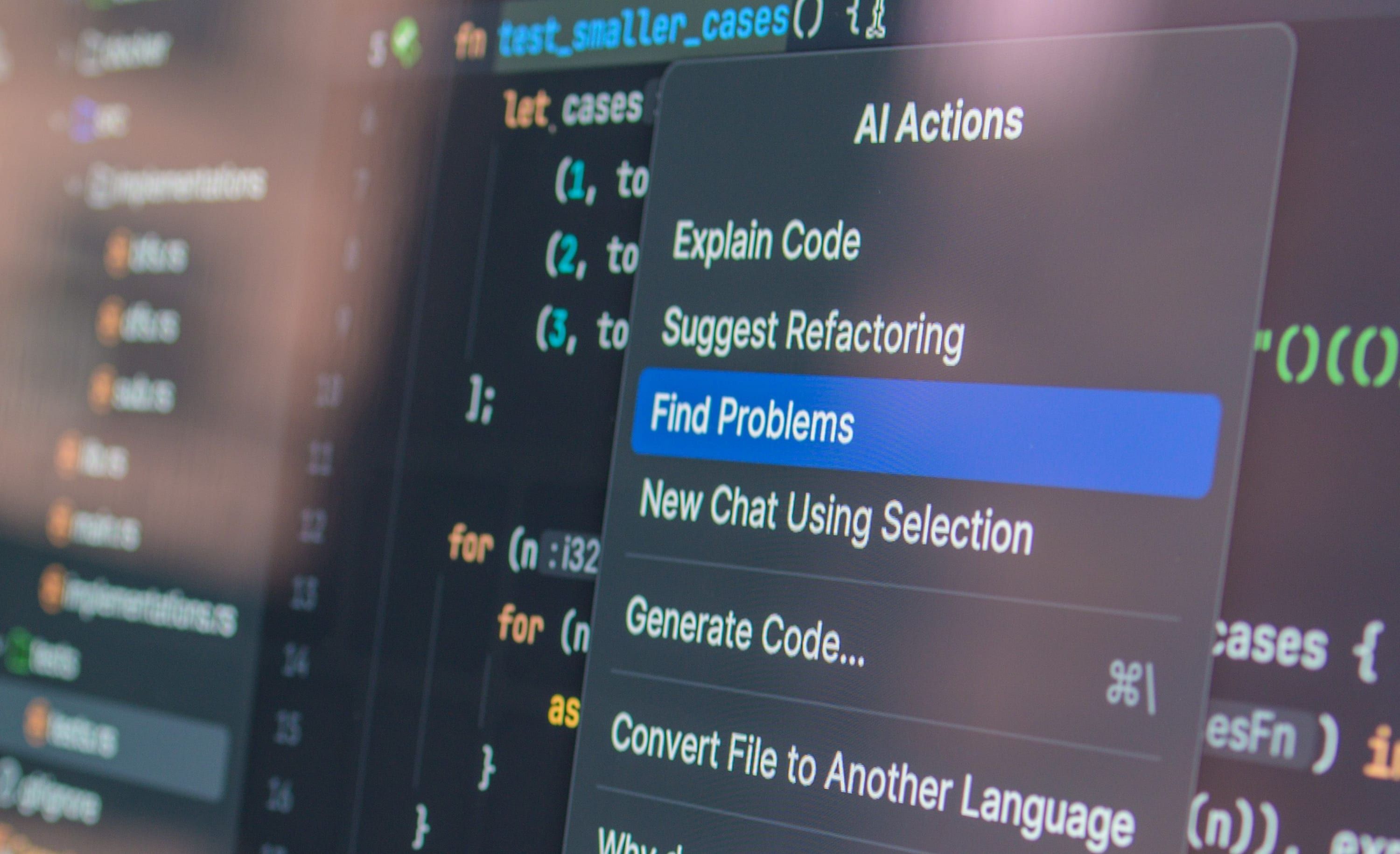 A laptop screen at an angle showing an editor with an assistant menu open, the room behind it out of focus.